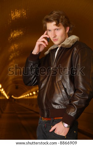 young adult in his 20s getting a mobile phone call in the old elbtunnel of hamburg.