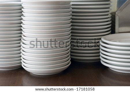 white plates stacked on brown wooden table