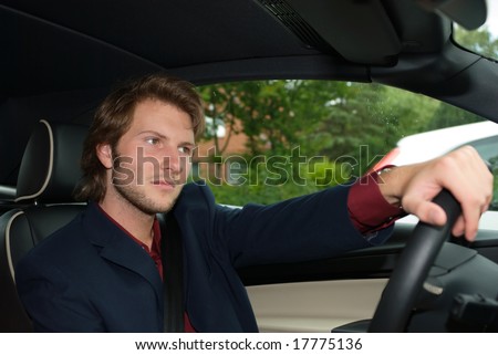 young adult driving a car in a relaxed position