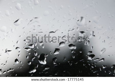 abstract water drops on glass surface on a gray rainy day