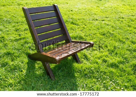 one chair on green field on a sunny day