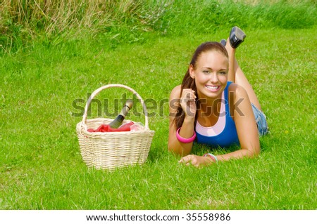 attractive smiling young girl with basket having outdoor picnic