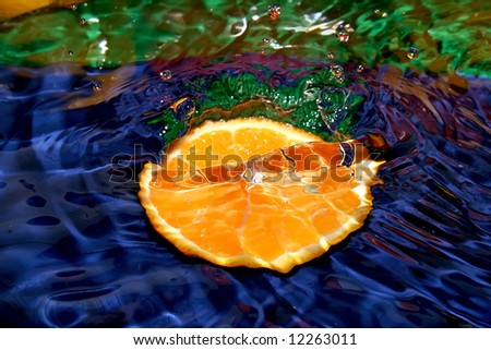 Splash with fresh mandarin. Pure water. Blue background.