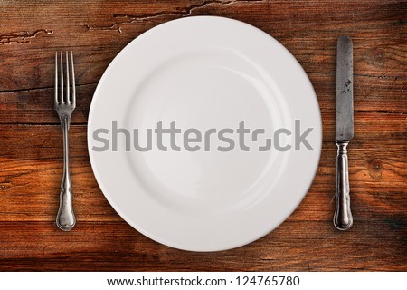 Plate, fork and knife on wooden table