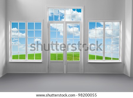 Room with large windows and green grass and blue sky behind (includes clipping path)