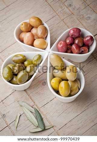 Multi colored olives on wooden table