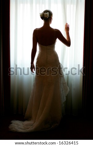  of a beautiful bride in a traditional white wedding dress stood