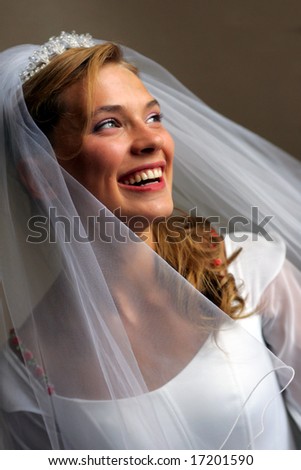 Portrait of beautiful bride in traditional white wedding dress smiling.