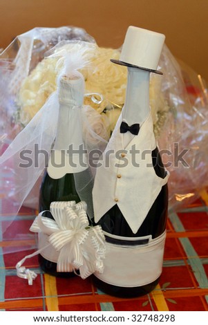 Decorated bottles of wedding wine and colorful bouquet of flowers.