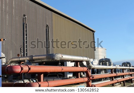Pipes on exterior of modern factory building.