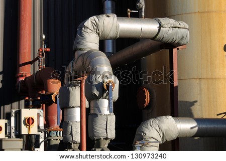 Exterior of industrial factory building with pipes and lagging.