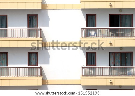 Closeup of hotel building with balconies and windows.