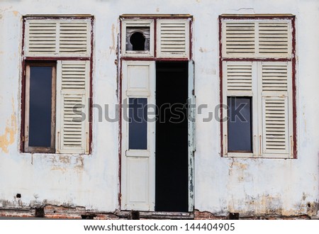 Abandoned Facade White Building showing ruined Wooden Door and windows