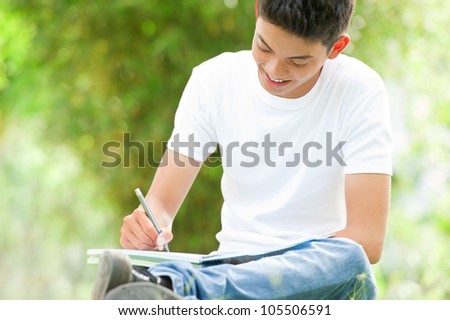 Smiling young student studying outside