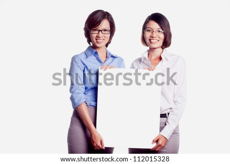 Young smiling women promoting big blank banner ad isolated on white background