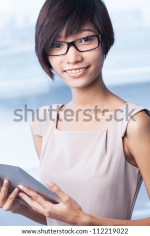 Vertical portrait of a stylish business lady holding a digital pad