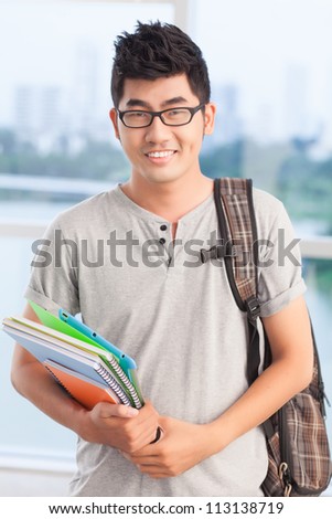 Portrait of a student guy with workbooks