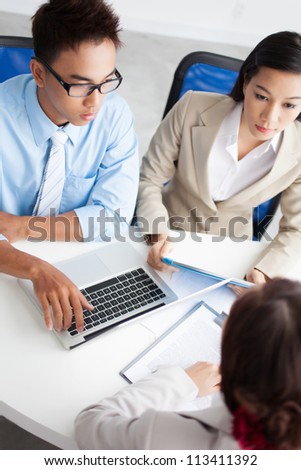 Vertical image of serious office workers discussing important business matters