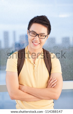 Portrait of a student guy standing at the window