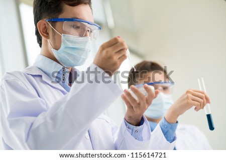 Lab workers wearing protective uniform studying samples