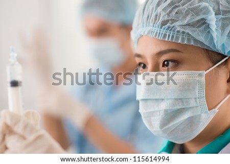 Close-up shot of a medical worker being ready to make an injection