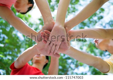 Close-up of pile of hands of teenagers