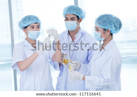 Group of laboratory workers testing substances before surgery