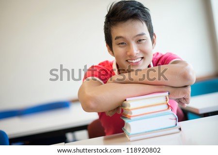 Close-up portrait of a happy college guy being fond of reading