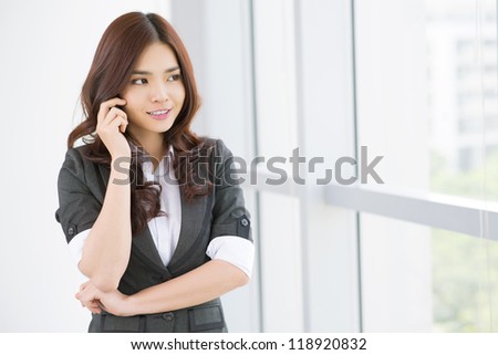 Friendly business lady talking to the client by mobile phone