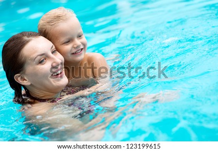 Cheerful family swimming in the pool to relax and have fun