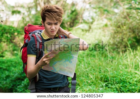 Thoughtful asian tourist standing in the forest