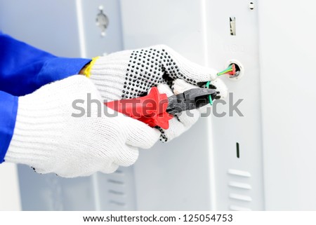 Close-up of an electrician using nippers to cut wires
