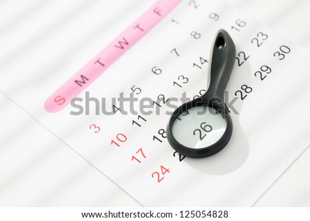 Close-up image of a calendar with a glass magnifying the most important date