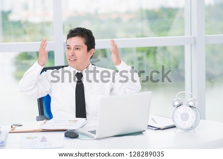 Portrait of an irritated businessman throwing up his hands
