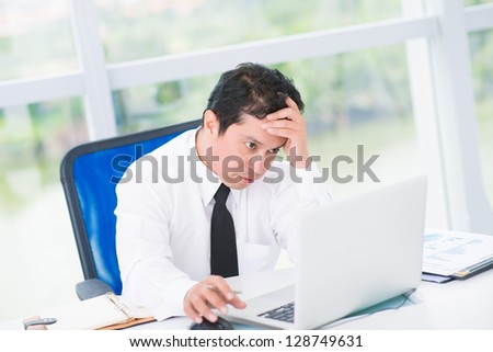 Portrait of a tired businessman looking in laptop