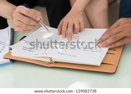 Closeup of people\'s hands working with the scheme