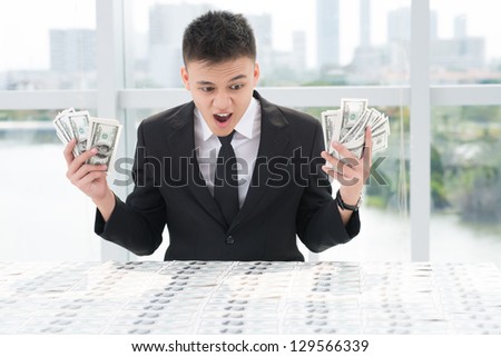 Portrait of an excited businessman with money in hands
