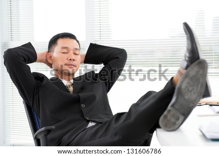 Portrait of a tired businessman relaxing at office
