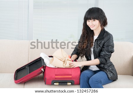 Portrait of a girl packing things and looking at camera