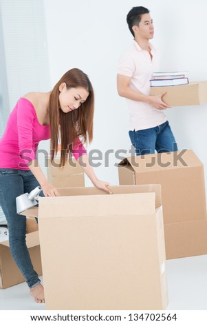 Young couple packing things for moving to a new house