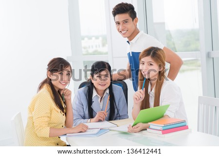Group portrait of three diligent students and their experienced teacher