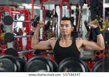 Image of a strong man lifting free-weights to build biceps