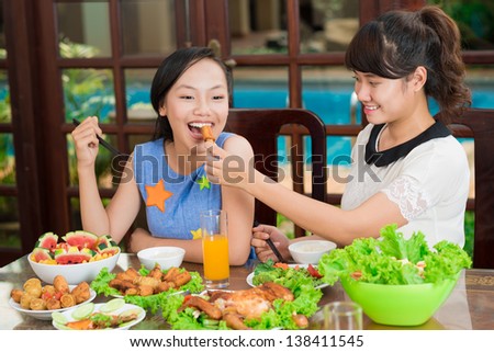 Image of two sisters eating delicious exotic food at home
