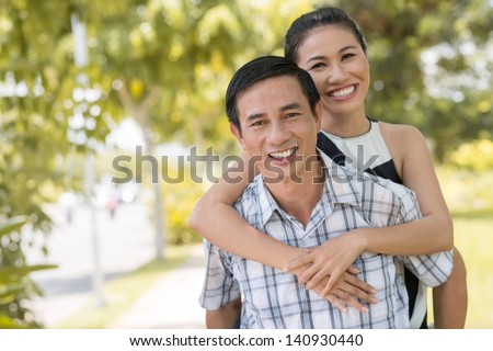 Copy-spaced portrait of a piggybacking couple outside