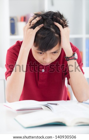 Vertical image of a tired schoolboy tired of reading inside