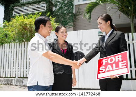 Image of new owners coming to an agreement with a realtor