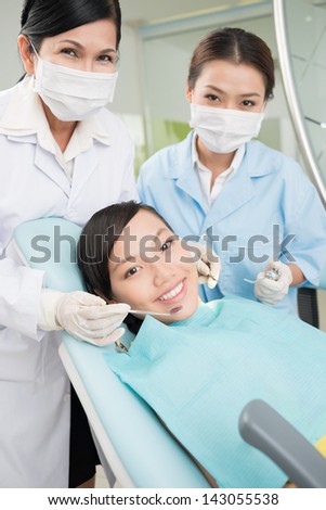 Vertical portrait of a teenager and dental doctors during the dental procedure