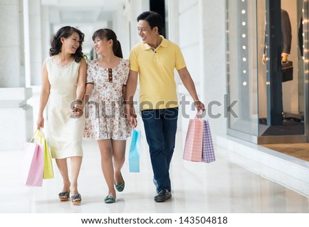 Full-length image of a happy family walking in the shopping-mall together