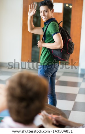 Vertical image of a student saying \'bye\'?Ã?ÃÂ to his fellow-student