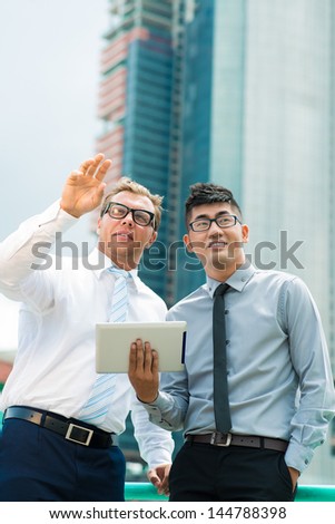 Vertical image of a business team discussing changes in the urban surroundings